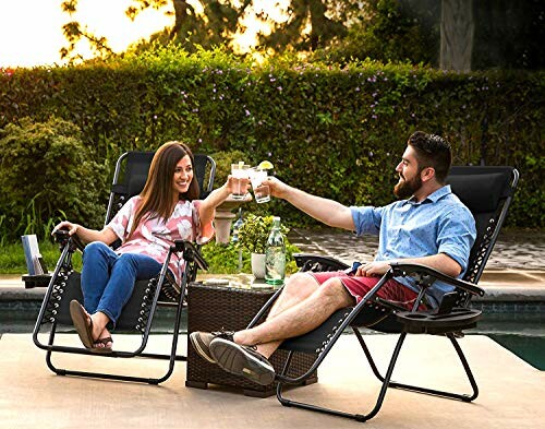 Two black reclining patio chairs with headrests and armrests