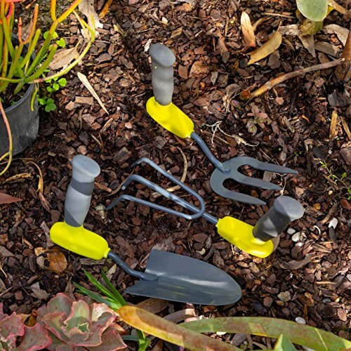 Garden tools including trowel, fork, and cultivator on soil