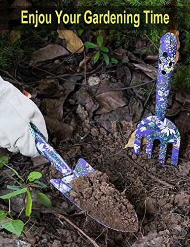 Colorful gardening tools in soil with plants.