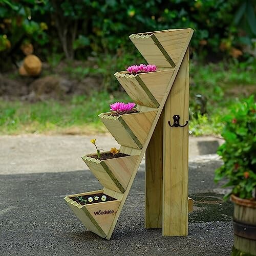 Wooden tiered planter stand with flowers on a patio.